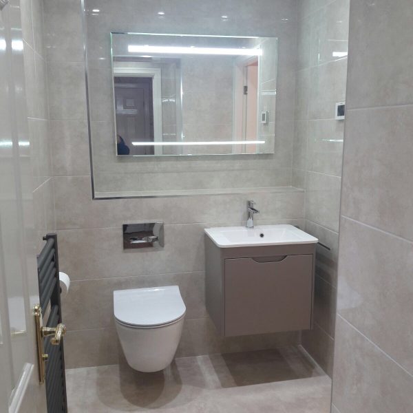 Back-lighted-mirror-in-ensuite-bathroom-with-grey-and-white-colour-scheme-600x600