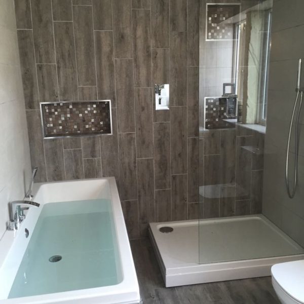 Family-bathroom-with-built-in-tiled-shelves-in-mosaic-greys-and-whites-600x600