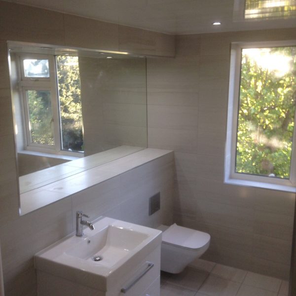 Family-bathroom-with-large-sink-and-full-tiles-and-mirror-600x600