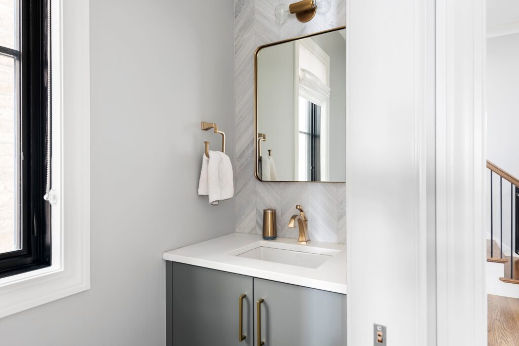 bathroom-with-brass-mirror-and-fixtures